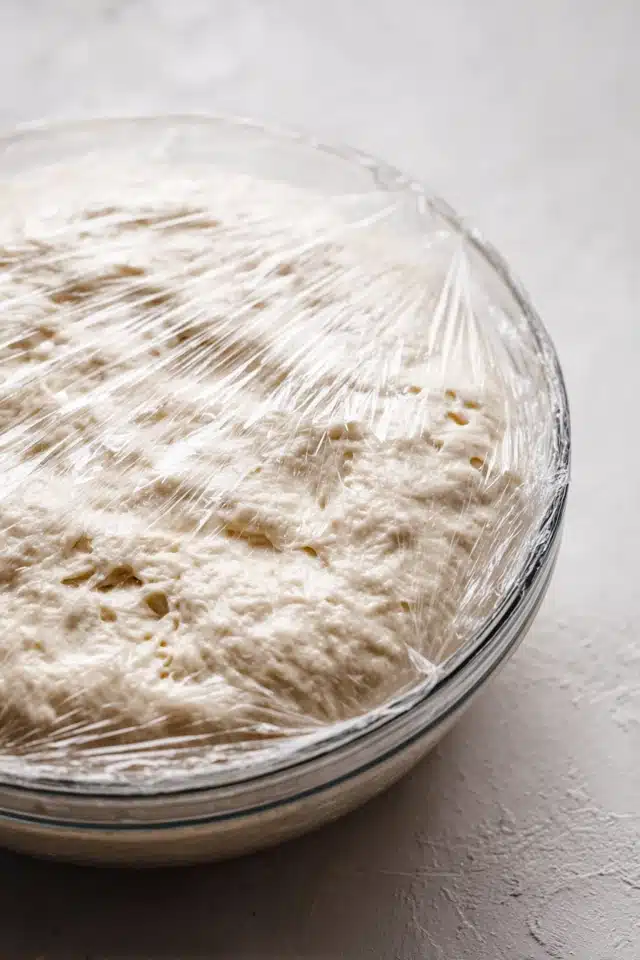 rolling cinnamon roll dough into a tight log with sugar filling